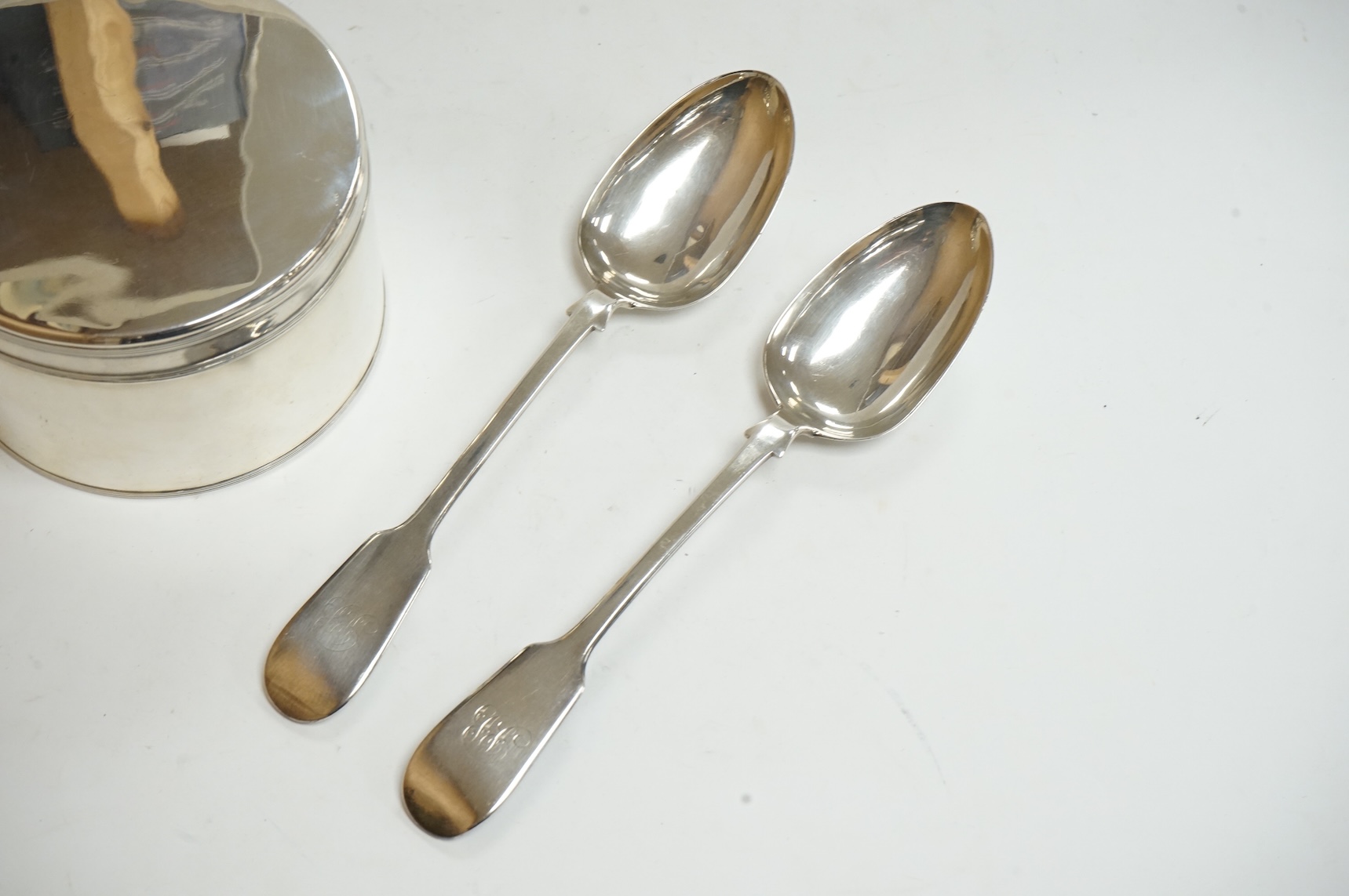 An early 19th century Dutch white metal circular biscuit box, with hinged cover and reeded bands, maker IT, retailed by Diemont, height 78mm, together with a pair of Victorian silver fiddle pattern table spoons by Willia